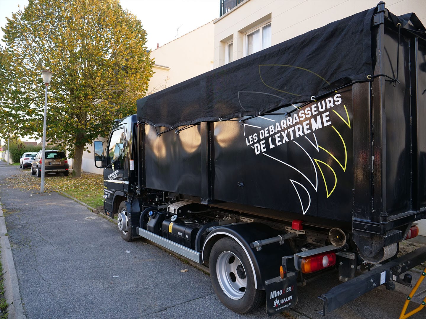 Camion de débarras garé dans une rue.