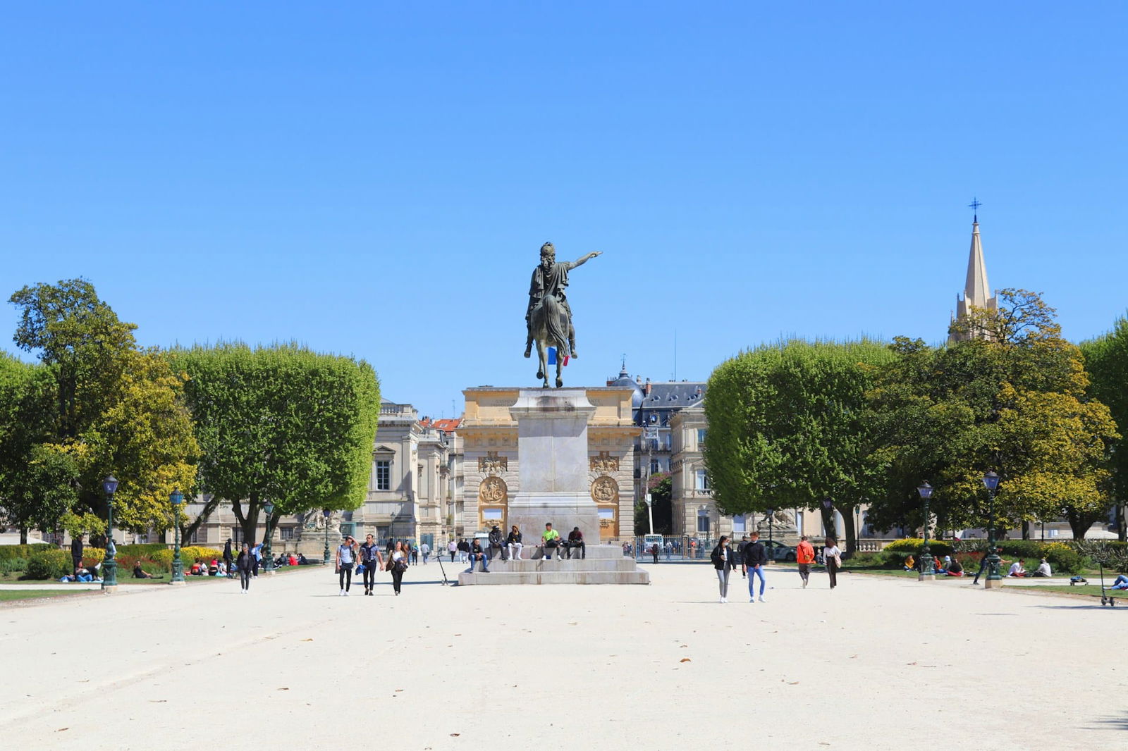 Statue équestre dans un parc avec visiteurs.