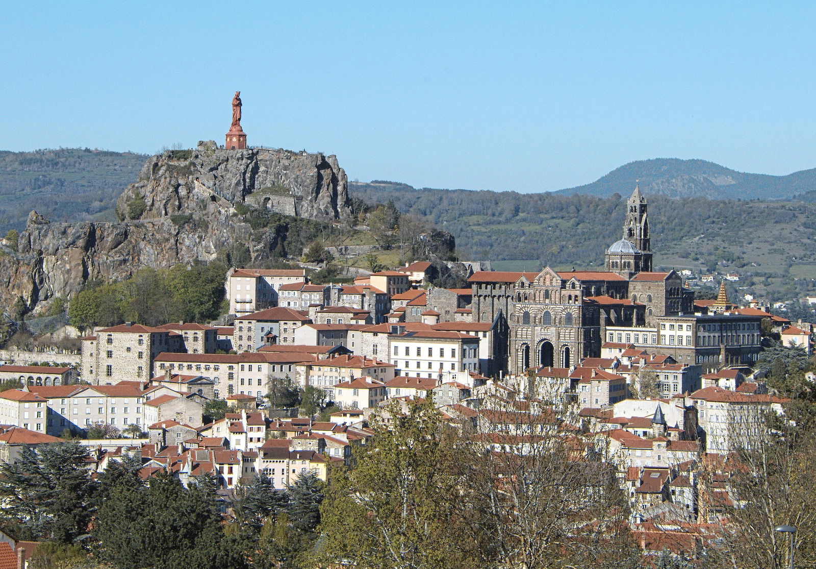 Vue du Puy-en-Velay avec statue et cathédrale.