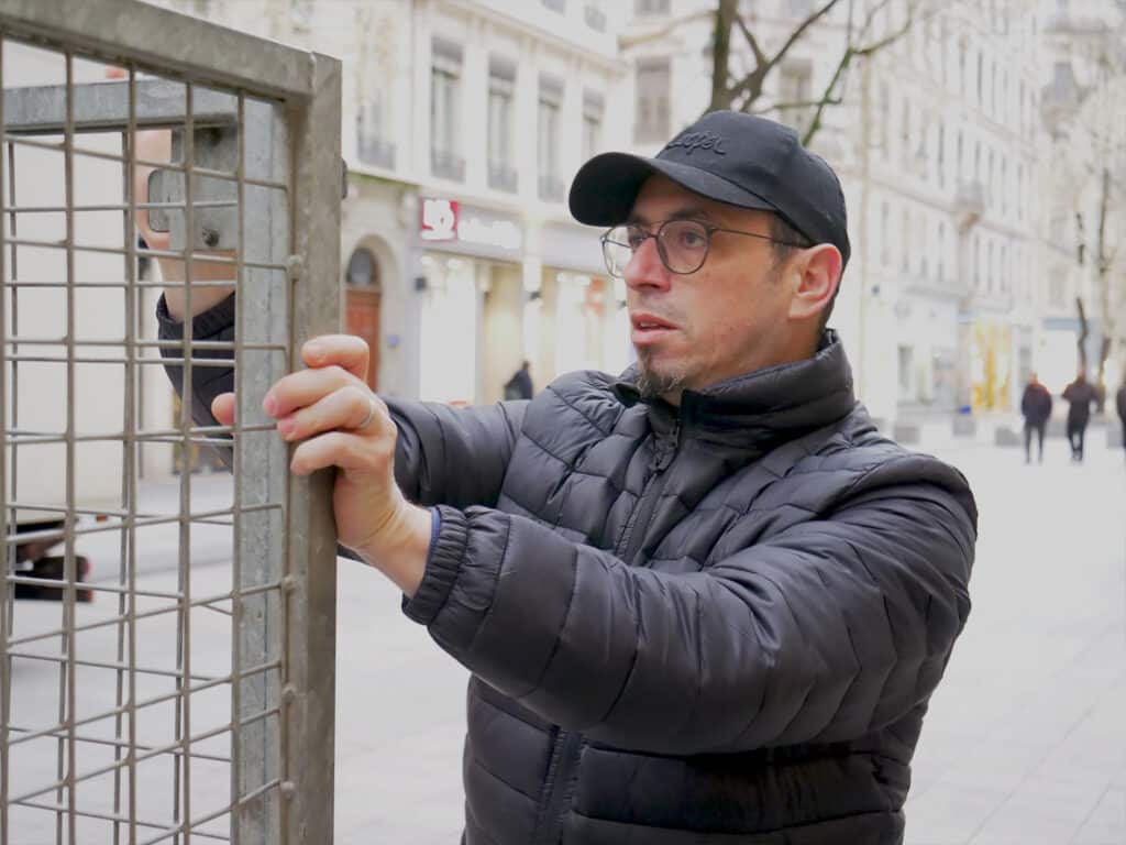 Homme inspectant structure métallique en extérieur urbain.